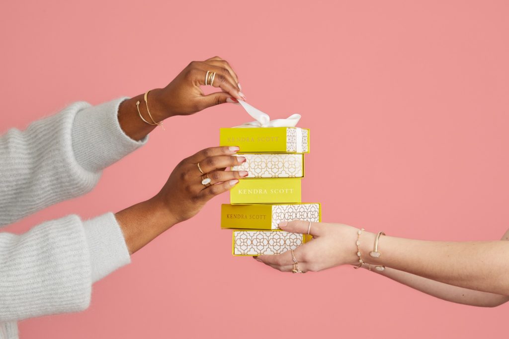 A person receiving a Kendra Scott gift from another person