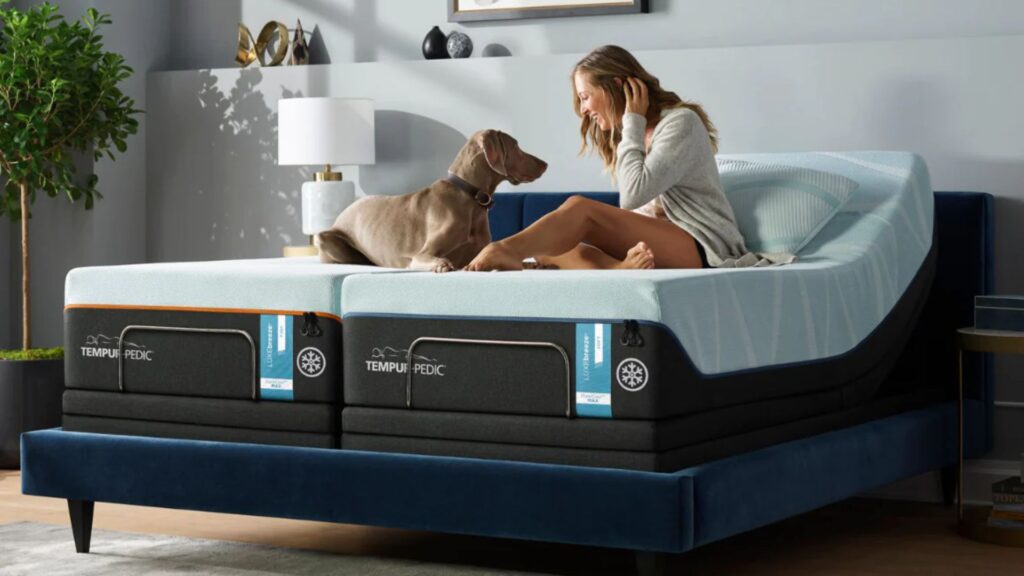 A woman laying in a Tempur-Pedic bed with a dog